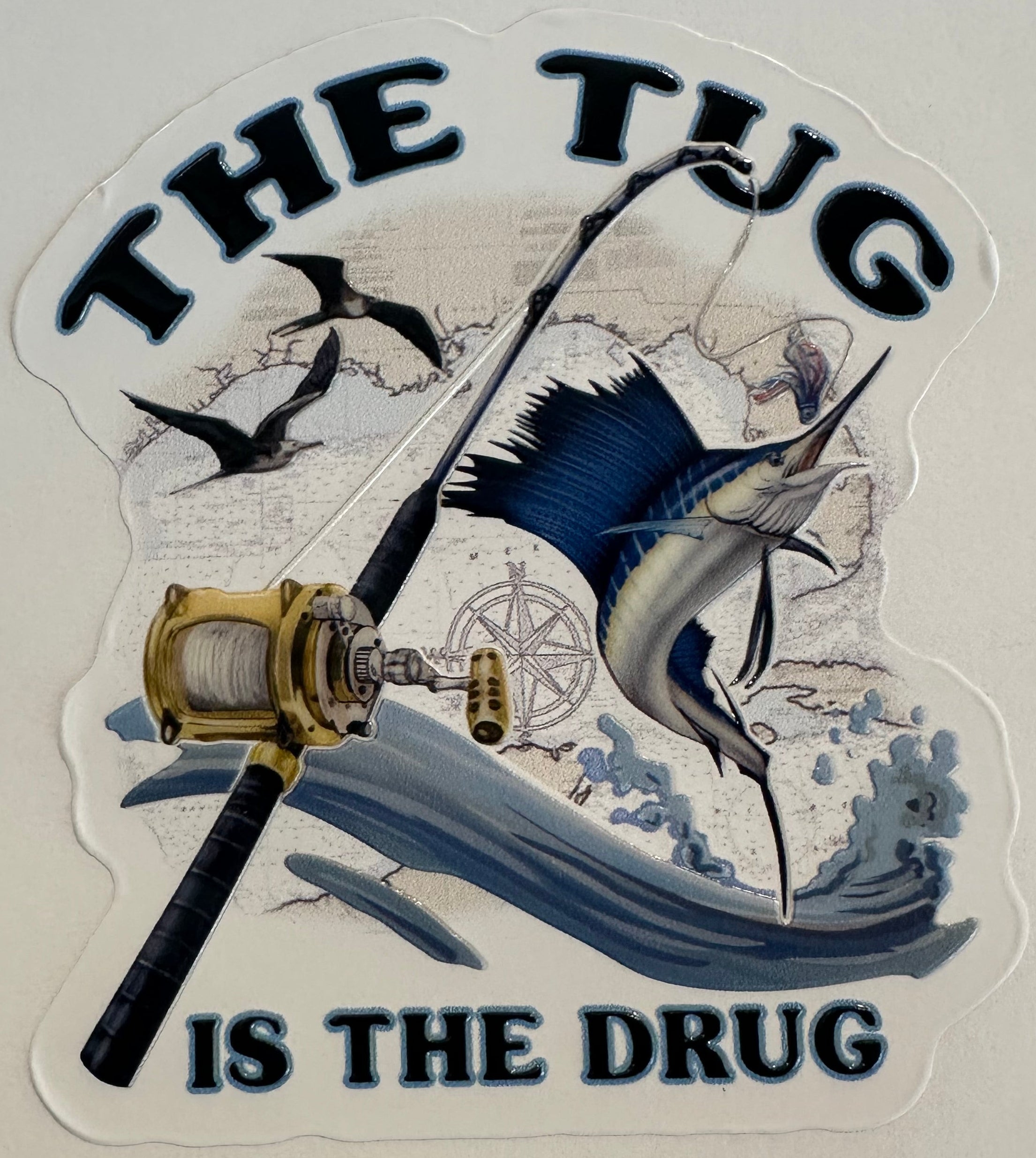 The Tug Is The Drug sailfish embossed fishing sticker with rod, reel, waves, and offshore artwork.
